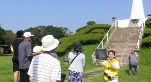 参加者に串良平和公園慰霊塔で解説する平和学習ガイド