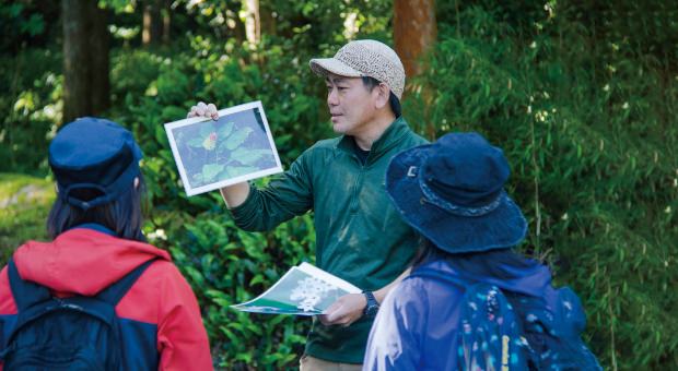 参加者に高山植物を説明する登山ガイド
